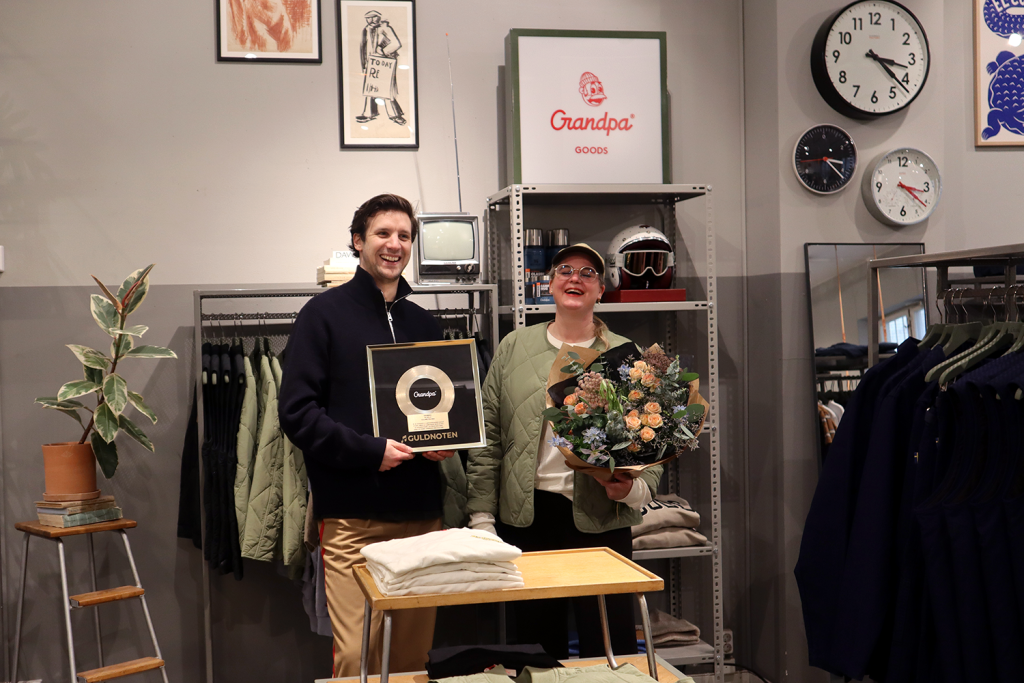 Helena, butikschef på Grandpas butik i Stockholm, tar emot priset för Guldnoten 2023 av Marcus Mihaylov, Key Account Manager på SAMI
